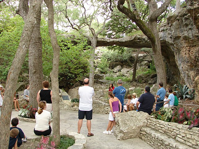 A group listens to instruction form a guide in front of the Natural Bridge Caverns
